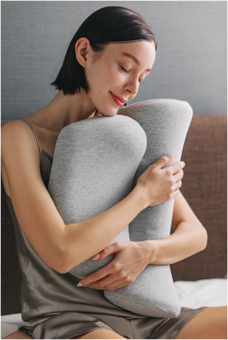 ダブルまくらを抱える女性